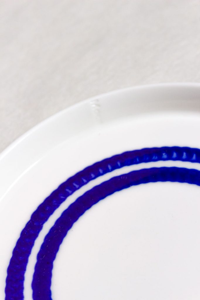 Close-up MOCA handmade ceramic dessert plate 16cm – two connected circular blue glaze lines, dripping texture